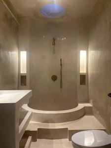 a bathroom with a shower with a toilet in it at CASA NARA BALI in Munggu