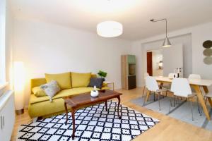 un soggiorno con divano giallo e tavolo di Central Vienna Charm - Comfortable 3-BR Stay a Vienna