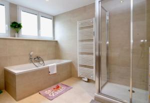 bagno con doccia, vasca e lavandino di Central Vienna Charm - Comfortable 3-BR Stay a Vienna