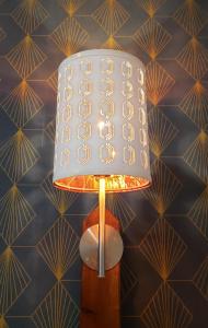 a lamp with a white shade on a wall at Domaine de Montauban in Perrancey