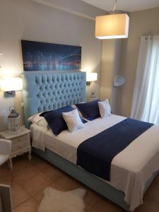 sypialnia z dużym łóżkiem z niebieskim zagłówkiem w obiekcie Machi Rooms w mieście Patitiri