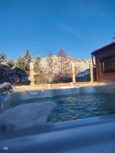 a swimming pool with snow on top of it at Appartement style montagne avec SPA in Égat