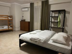 een slaapkamer met een bed met witte lakens en kussens bij Babilon Hotel Tbilisi in Tbilisi City
