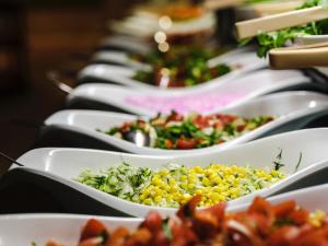 a row of white bowls filled with different types of food at Trinity Residence Bansko in Bansko