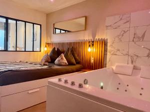 1 dormitorio con cama y bañera en Le Nid de la Chouette - Gare & Cité by Apparts Spa Dijon, en Dijon