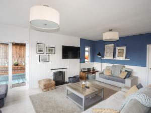 a living room with a couch and a fireplace at Nyth Y Fran in Abersoch