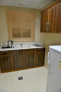 una cucina con lavandino e frigorifero di المواسم الاربعة للاجنحه الفندقية ad Al Jubail
