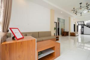 a living room with a couch and a table at RedDoorz Syariah at Jalan Andalas Padang in Kampungdurian