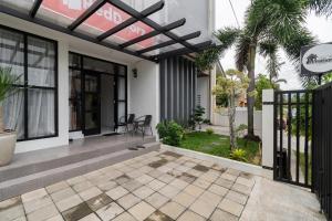 a front porch of a house with a pergola at RedDoorz Syariah at Jalan Andalas Padang in Kampungdurian