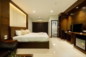 ein Hotelzimmer mit einem Bett und einem TV in der Unterkunft บีวินรีสอร์ท in Nakhon Si Thammarat