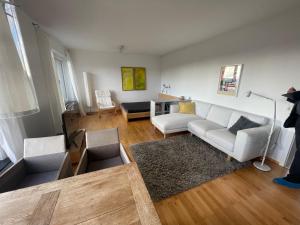 ein Wohnzimmer mit einem weißen Sofa und einem Tisch in der Unterkunft A Home away from Home in Ravensburg