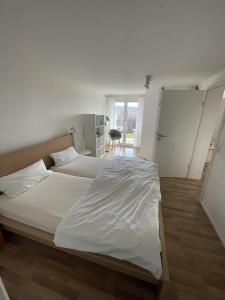a large white bed in a room with a window at A Home away from Home in Ravensburg