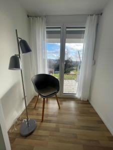 ein schwarzer Stuhl in einem Zimmer mit Fenster in der Unterkunft A Home away from Home in Ravensburg