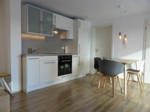 a kitchen with white cabinets and a table and chairs at A Home away from Home in Ravensburg