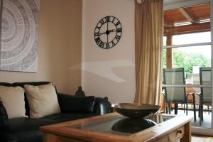 un salon avec une horloge au mur dans l'établissement Ferienwohnung am Herrnberg, à Prien am Chiemsee