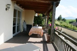 een tafel op de veranda van een huis bij Ferienwohnung am Herrnberg in Prien am Chiemsee