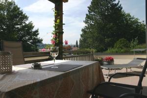 une table avec un verre de vin sur une terrasse dans l'établissement Ferienwohnung am Herrnberg, à Prien am Chiemsee 3 autres photos