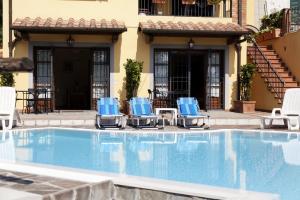 una piscina con sillas azules y un edificio en Montefiore Casa Vacanze, en Lamporecchio