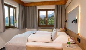 Schlafzimmer mit einem großen weißen Bett und Fenstern in der Unterkunft Chalet Edelweiß in Pfronten