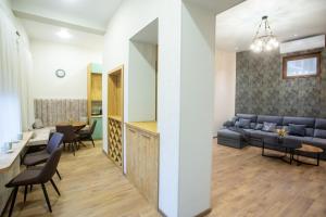 a living room with a couch and a table and chairs at Nino's Cosy Apartment in Kutaisi