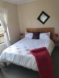 Un dormitorio con una cama con una manta roja encima. en 15 on 11th Summerstrand, en Summerstrand