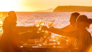 een groep mensen die rond een tafel zitten met een glas wijn bij Hotel Splendid in Dubrovnik
