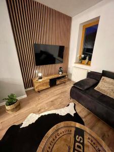 a living room with a couch and a flat screen tv at Apartmán MATEO Donovaly in Donovaly