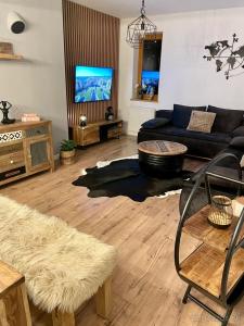 a living room with a couch and a tv at Apartmán MATEO Donovaly in Donovaly