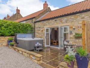 an extension to a stone house with a jacuzzi at Thistle Cottage - Uk30523 in Staintondale