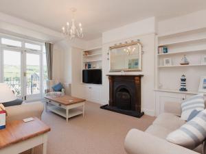 a living room with a fireplace and a tv at Estuary View in Salcombe