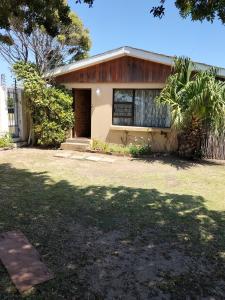 una casa con un árbol delante en 15 on 11th Summerstrand, en Summerstrand