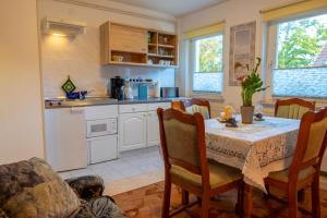 a kitchen with a table and chairs and a kitchen with a table and a table at Haus Parchow in Baabe