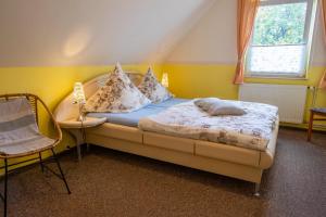 a bedroom with a bed with pillows and a chair at Haus Parchow in Baabe