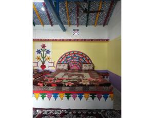 sypialnia z łóżkiem z kolorową narzutą w obiekcie Rann Chandni Resort, Kutch, Bhuj w mieście Bherandiāla