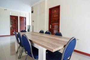 Makale的住宿－RedDoorz at Makale Tana Toraja，一间会议室,配有木桌和椅子