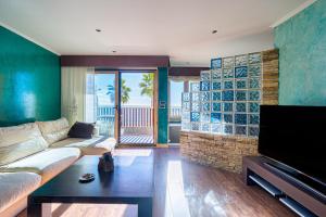 a living room with a couch and a flat screen tv at Apto Villajoyosa 1ª línea in Villajoyosa