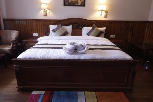 a bedroom with a large bed with a white towel on it at Hotel De Villa Gangtok in Gangtok