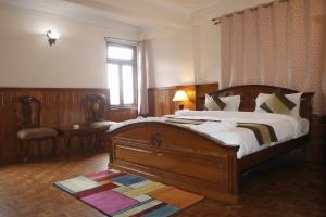 a bedroom with a large wooden bed and a window at Hotel De Villa Gangtok in Gangtok