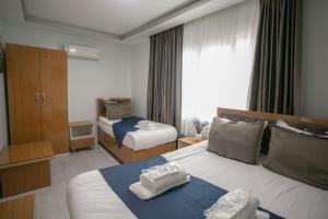 a hotel room with two beds with towels on them at Güven House İstanbul in Istanbul