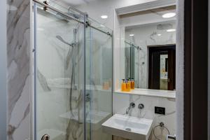 W łazience znajduje się szklana kabina prysznicowa i umywalka. w obiekcie Pension Montana Popa w mieście Blaj