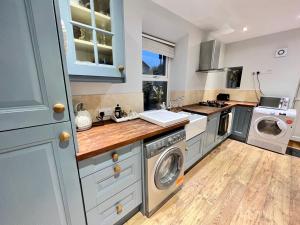 uma cozinha com uma máquina de lavar roupa e uma máquina de lavar e secar roupa em Bank View next to the Fleece Countryside Inn em Barkisland