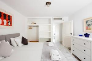 a white bedroom with a large white bed with towels on it at Villa Maestro Mykonos in Agios Ioannis Mykonos