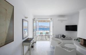 a white living room with a view of the ocean at Villa Maestro Mykonos in Agios Ioannis Mykonos