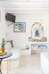 a living room with a table with a bowl of fruit on it at Villa Maestro Mykonos in Agios Ioannis Mykonos