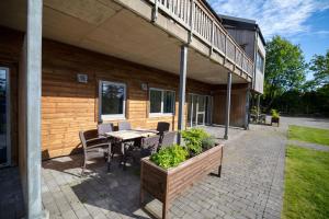 eine Terrasse mit einem Tisch und Stühlen vor einem Gebäude in der Unterkunft Kristiansand Feriesenter in Kristiansand