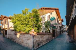 una pared de piedra con un árbol en una calle en Mediterra Art Hotel Antalya, en Antalya