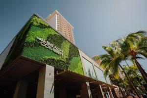a building with a green wall with a sign on it at OUTRIGGER Waikiki Beachcomber Hotel in Honolulu