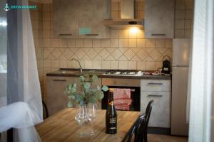 a kitchen with a table with wine bottles and glasses at Casa Vacanze Naxos in Lido di Ostia