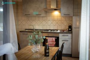 a kitchen with a table with wine bottles and glasses at Ostia Holiday Naxos in Lido di Ostia