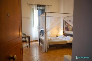 a bedroom with a bed with a canopy at Ostia Holiday Naxos in Lido di Ostia